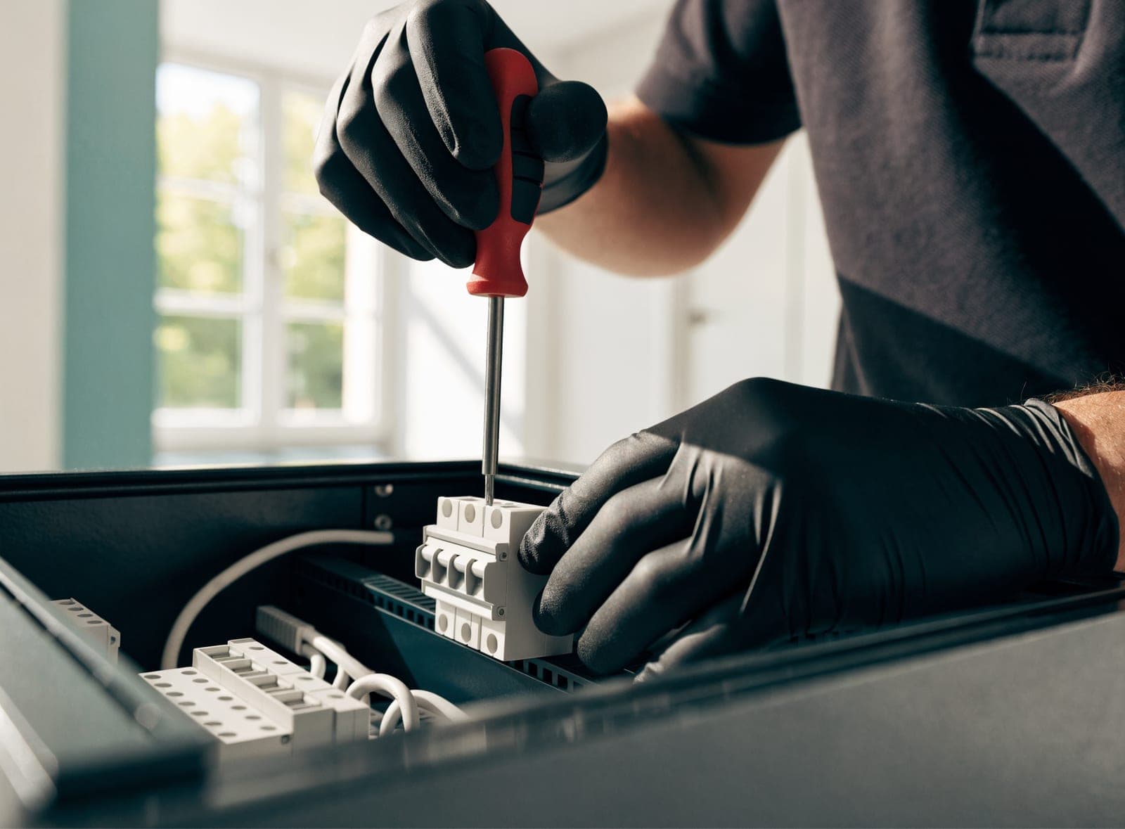 Monteur plaatst een installatieautomaat in een geopende groepenkast